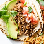 up close view of vegan street tacos with walnut meat on corn tortillas.