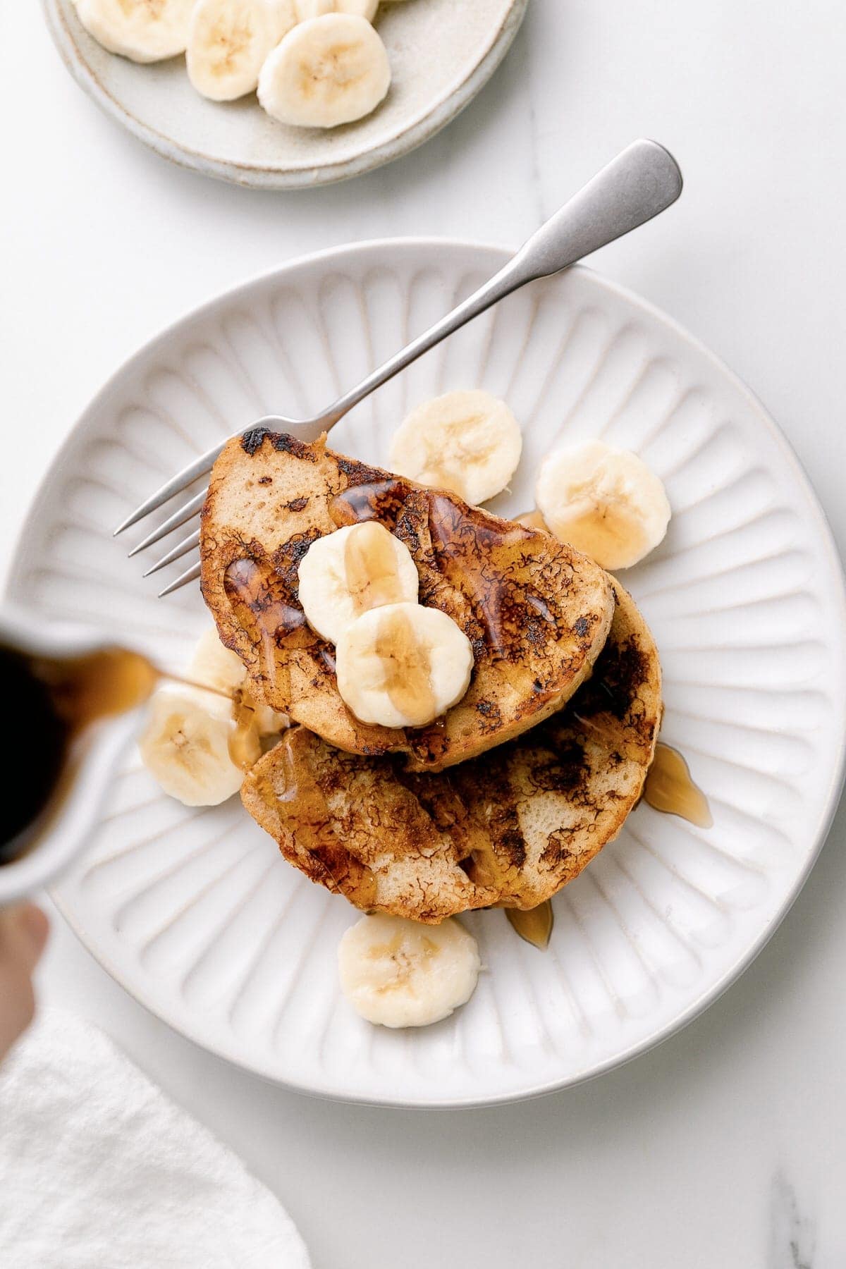 top down view of banana french toast on a plate with fork.