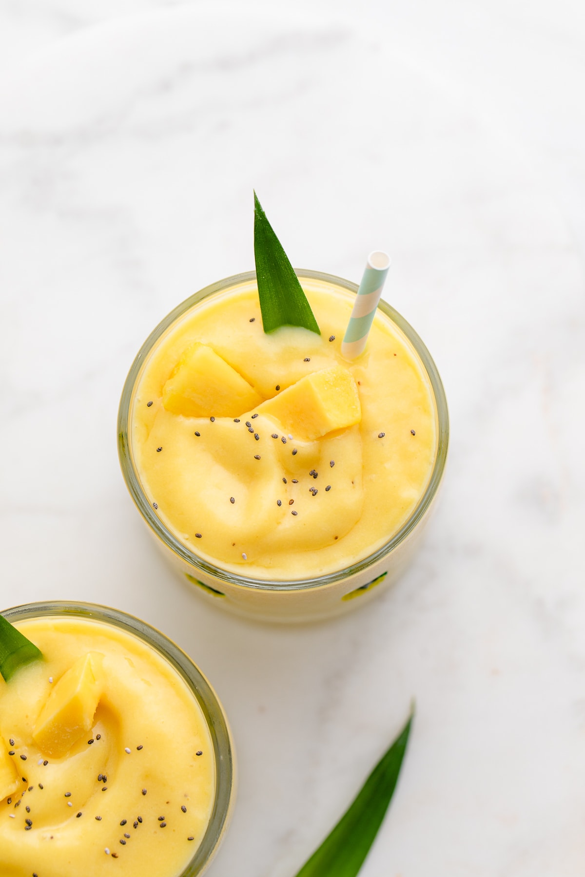 top down view of pineapple mango banana smoothie in a glass.