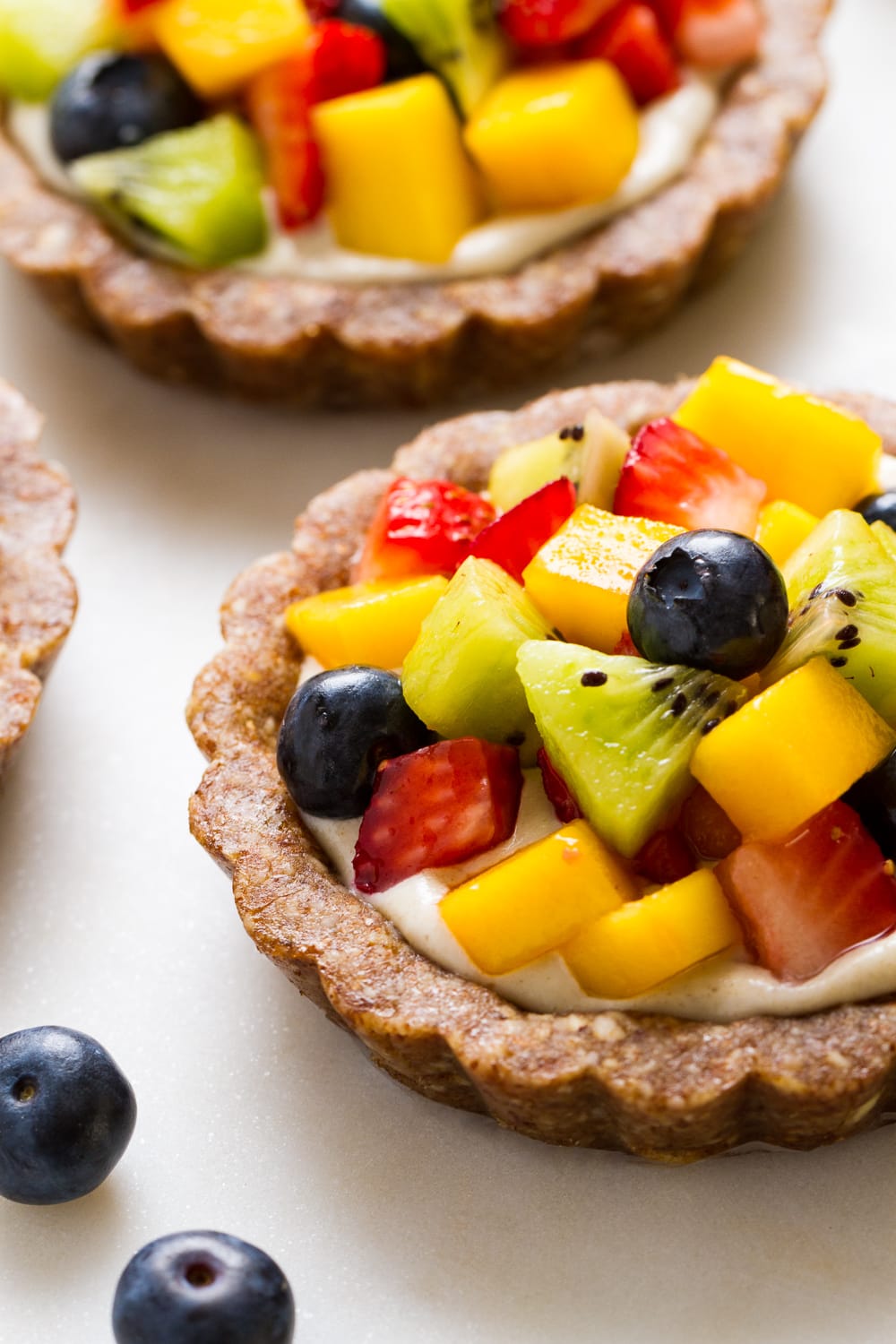 raw fruit tartlet on a marble serving board.