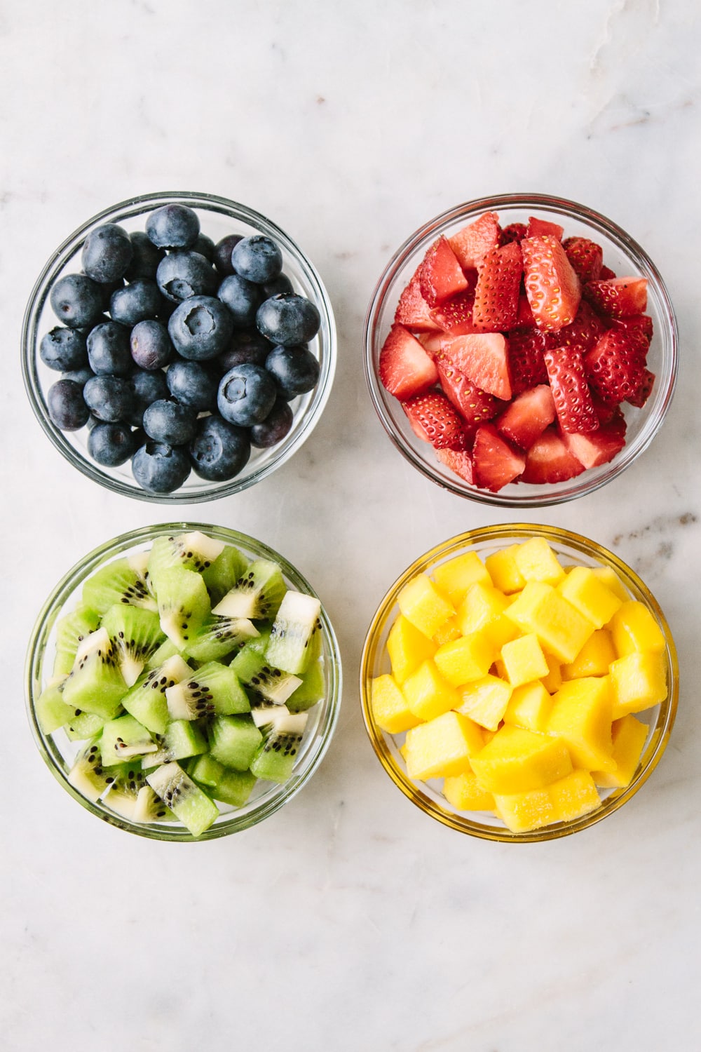 top down view of assorted diced fruits to top on raw fruit tarts.