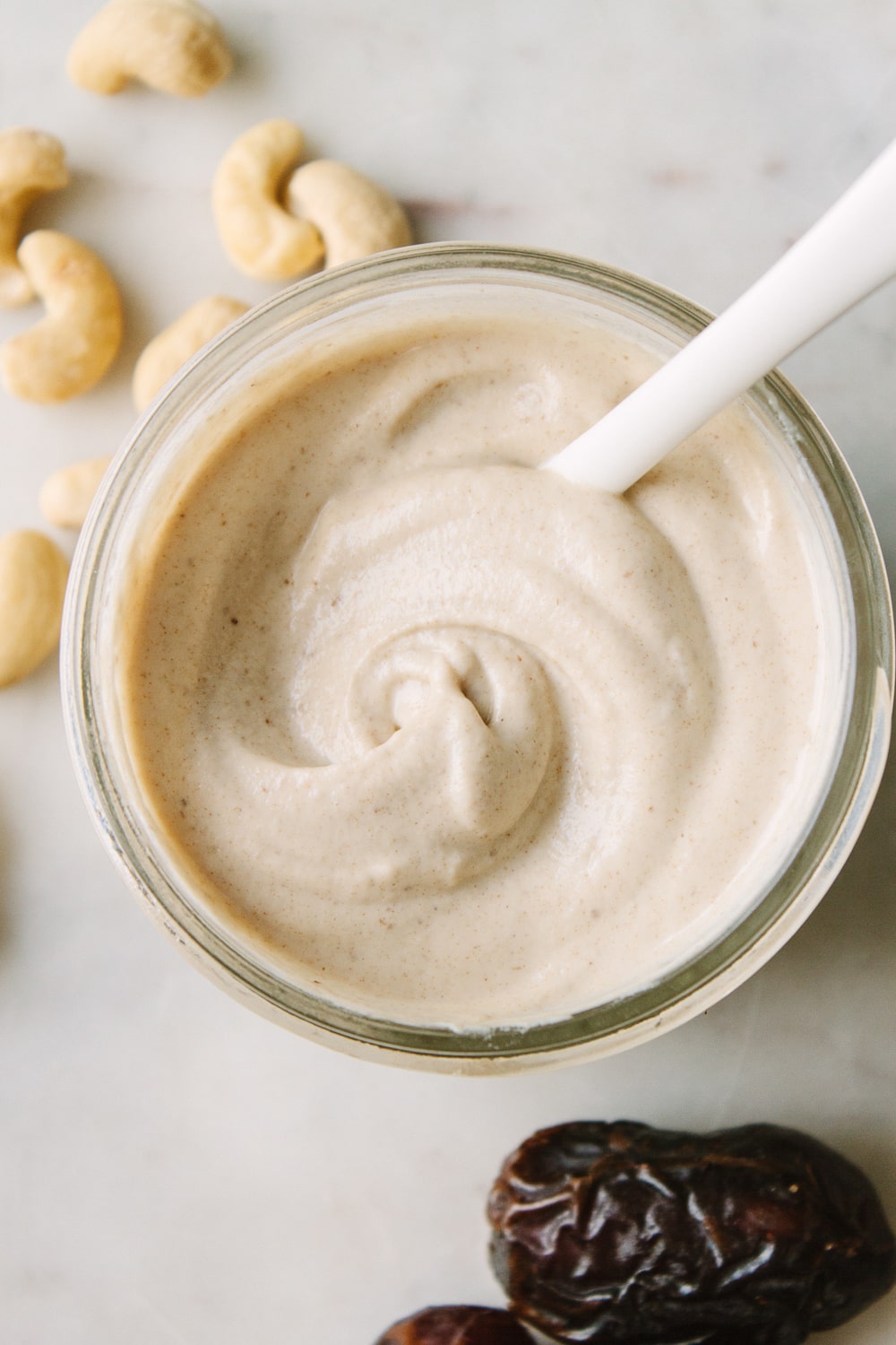 top down view of homemade cashew sweet cream in a bowl with a spoon.