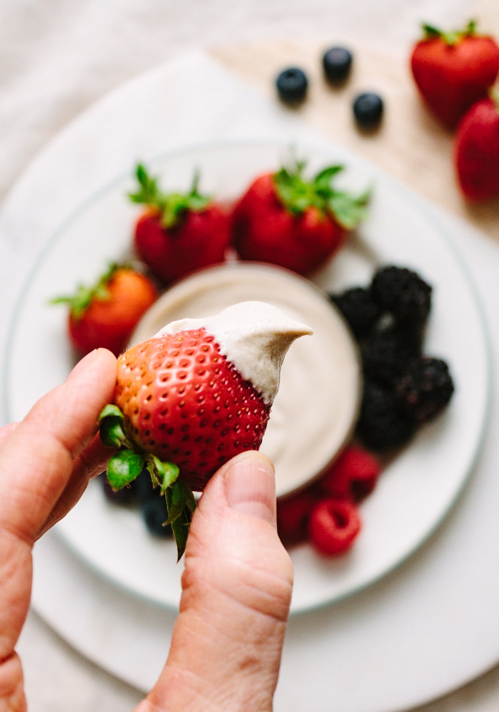 up close view of strawberry dipped with cashew sweet cream.