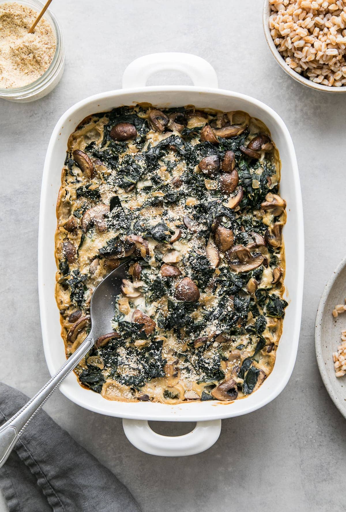 top down view of freshly baked vegan mushroom gratin with kale with a sprinkle of almond parmesan.