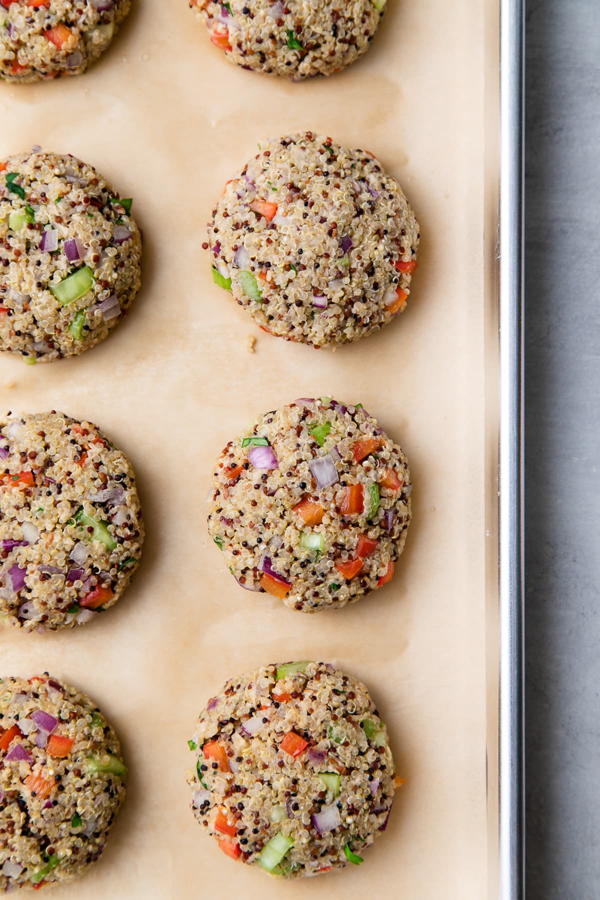 top down view of freshly formed quinoa cakes on a baking sheet.