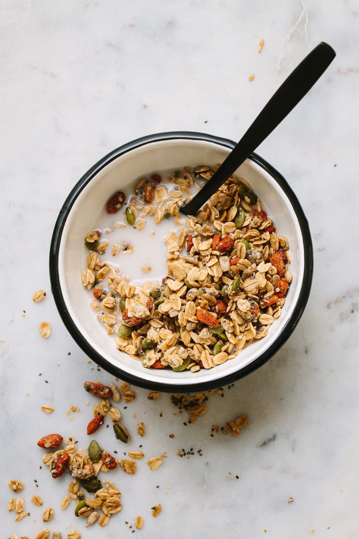 top down view of oil free seeds and goji berry granola in a bowl with spoon.