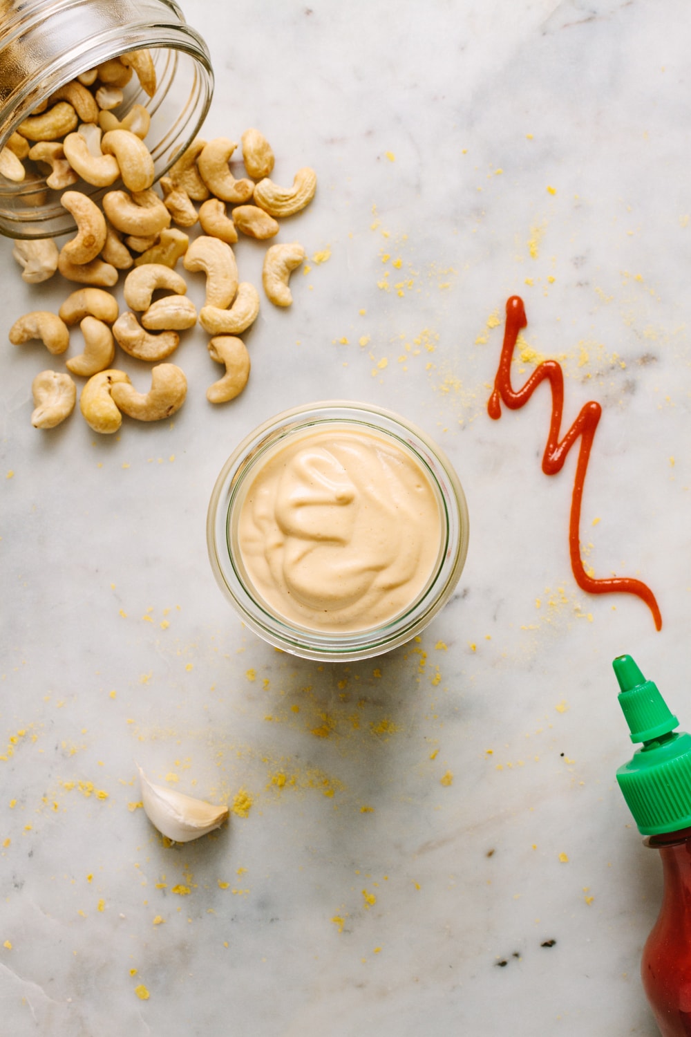 top down view of sriracha cashew cheese sauce in a small glass jar.