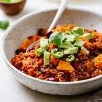 side angle view of a bowl with a serving of healthy vegan sweet potato quinoa chili with spoon.