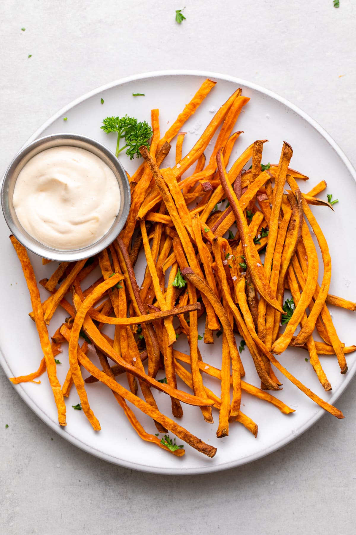 top down view of plate of freshly made baked crispy sweet potato shoestring fries.