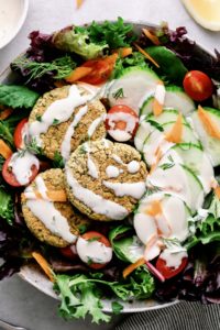 top down view of baked falafel salad with tahini dressing.