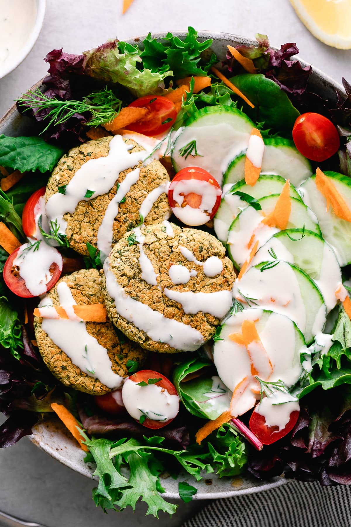 top down view of baked falafel salad with tahini dressing.