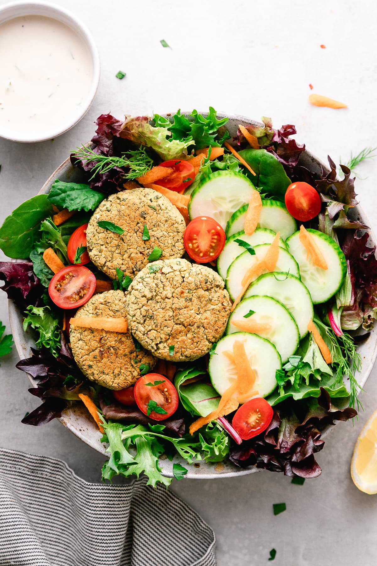 top down view of baked falafel salad with items surrounding.