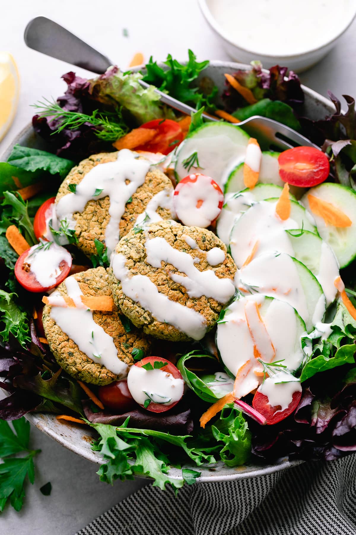 top down view of baked falafel salad with tahini dressing.