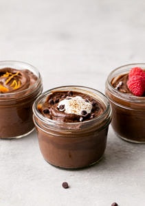 side angle view of 3 mason jars with healthy raw chocolate avocado pudding.