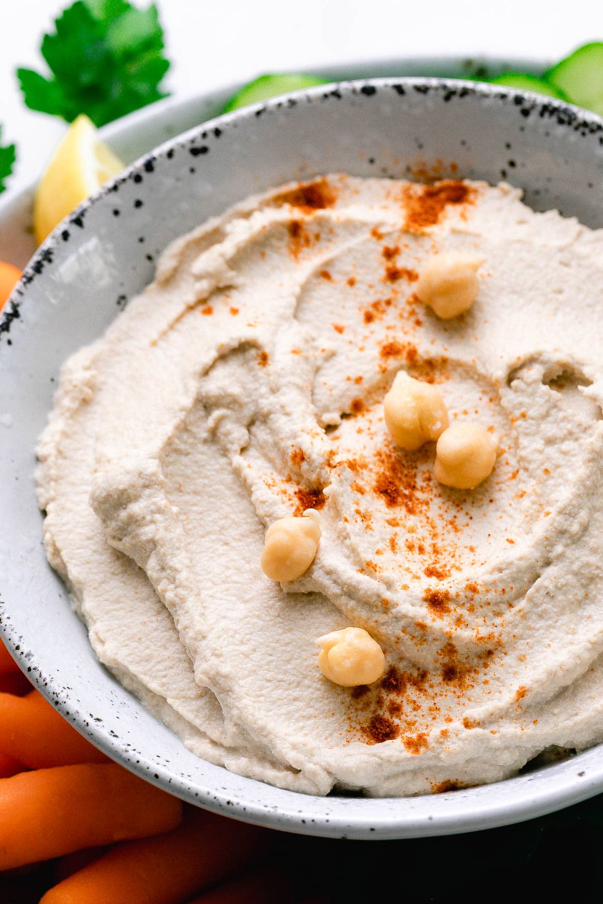 side angle view of raw sprouted hummus in a bowl with sprouted chickpeas on top.