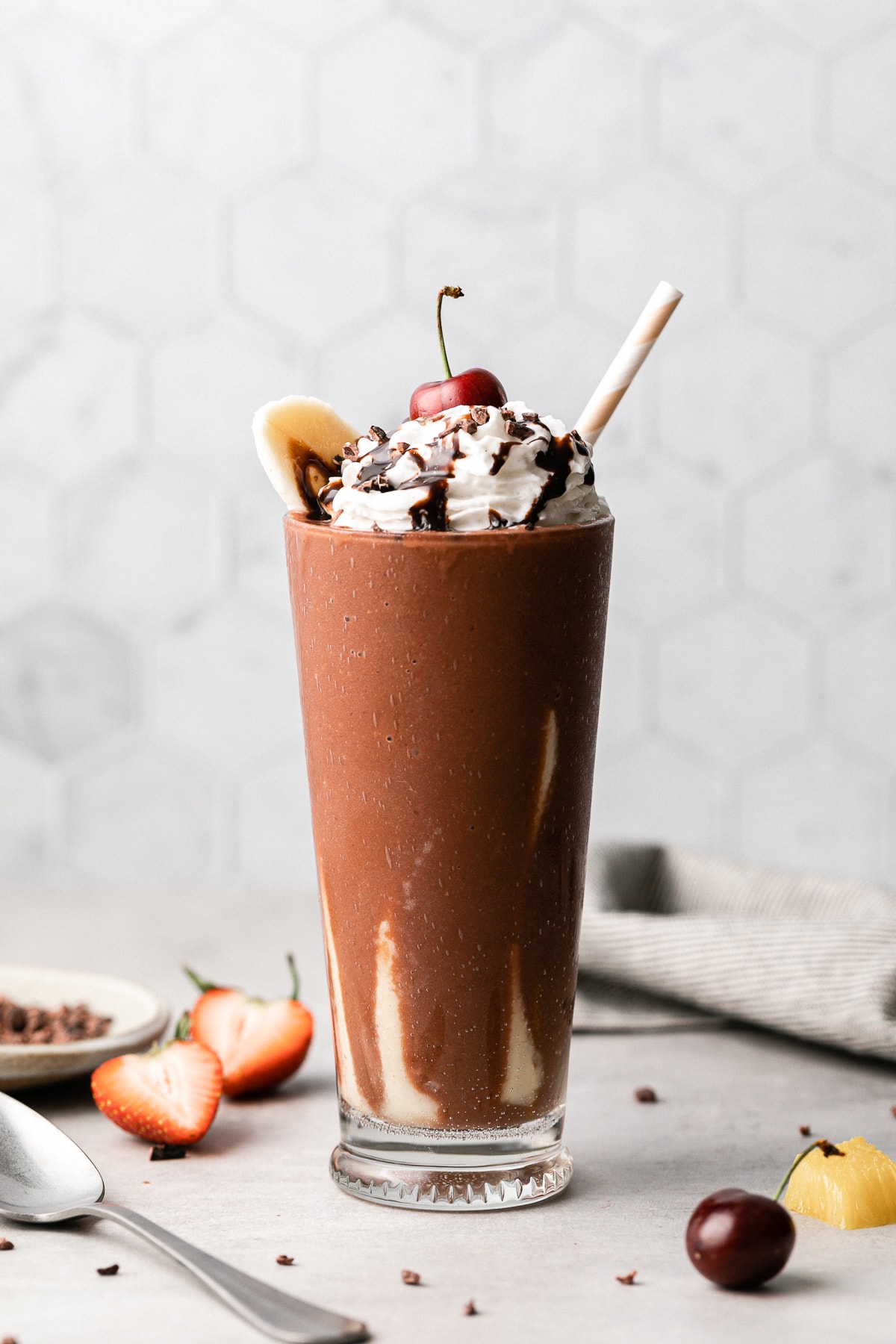 head on view of banana split smoothie in a tall glass.