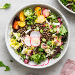 top down view of french lentil and bitter greens salad in a bowl.