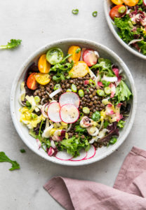 top down view of french lentil and bitter greens salad in a bowl.