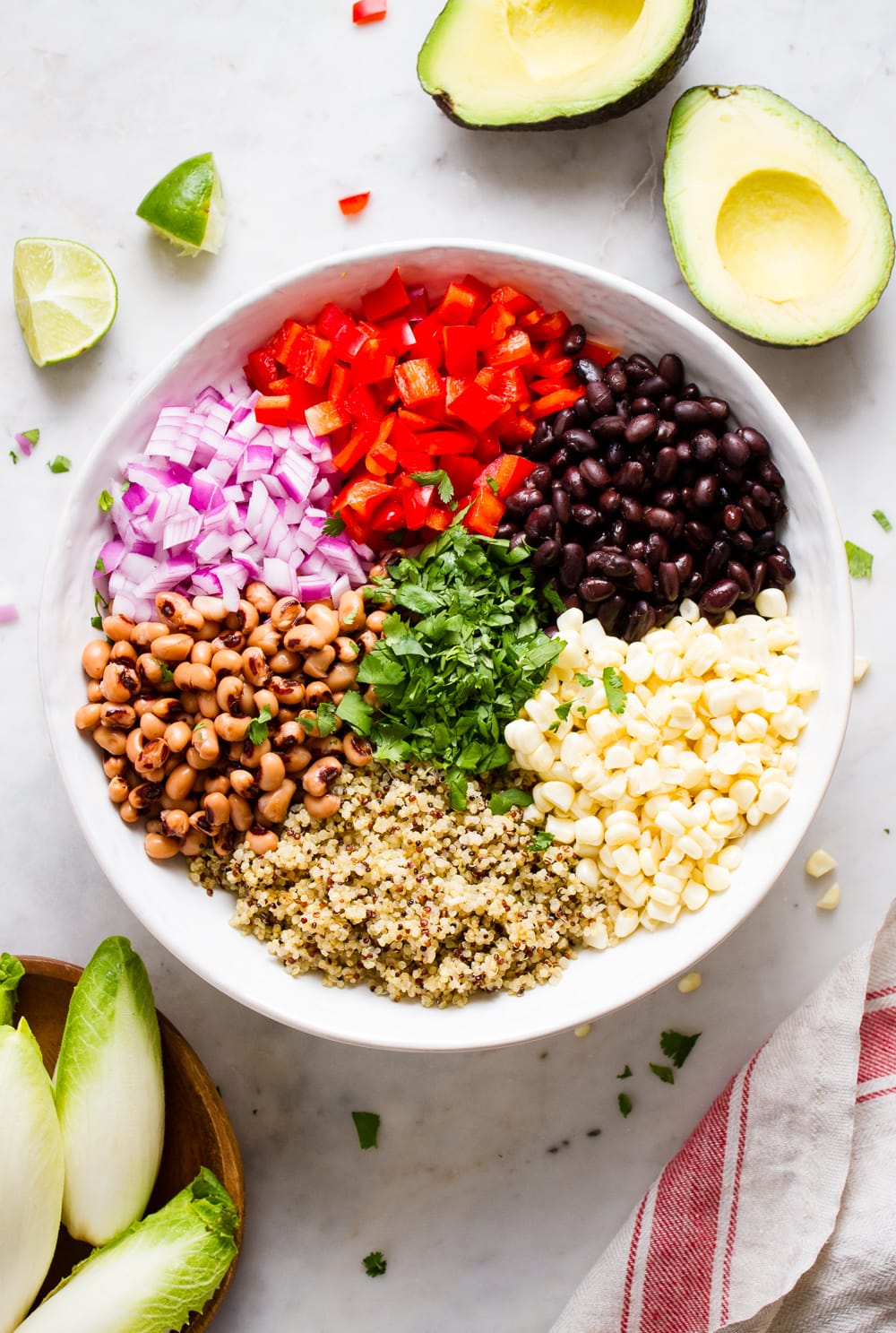 top down view of the process of adding ingredients to serving bowl for quinoa cowboy caviar.