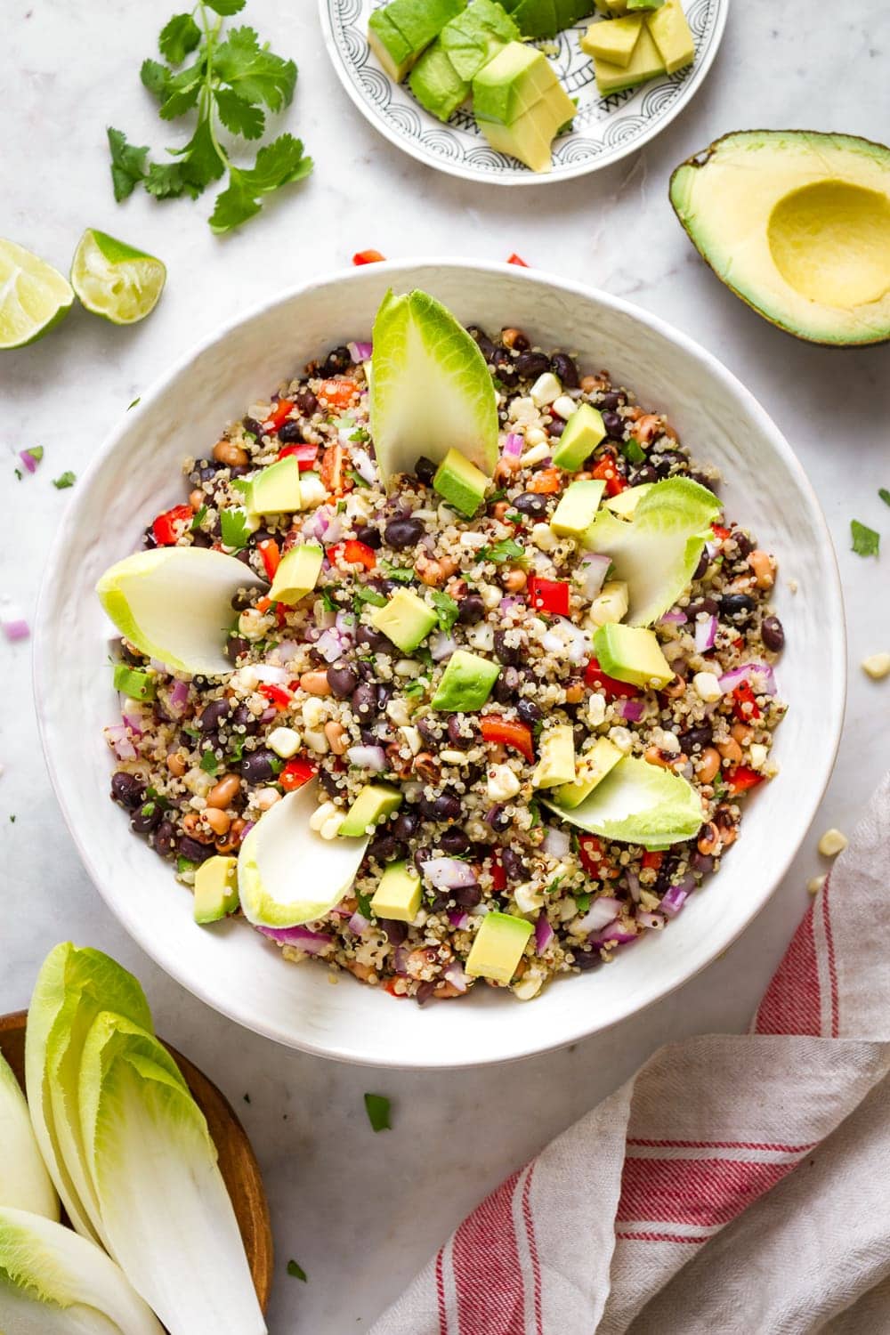 top down view of cowboy caviar quinoa salad in a bowl with items surrounding.