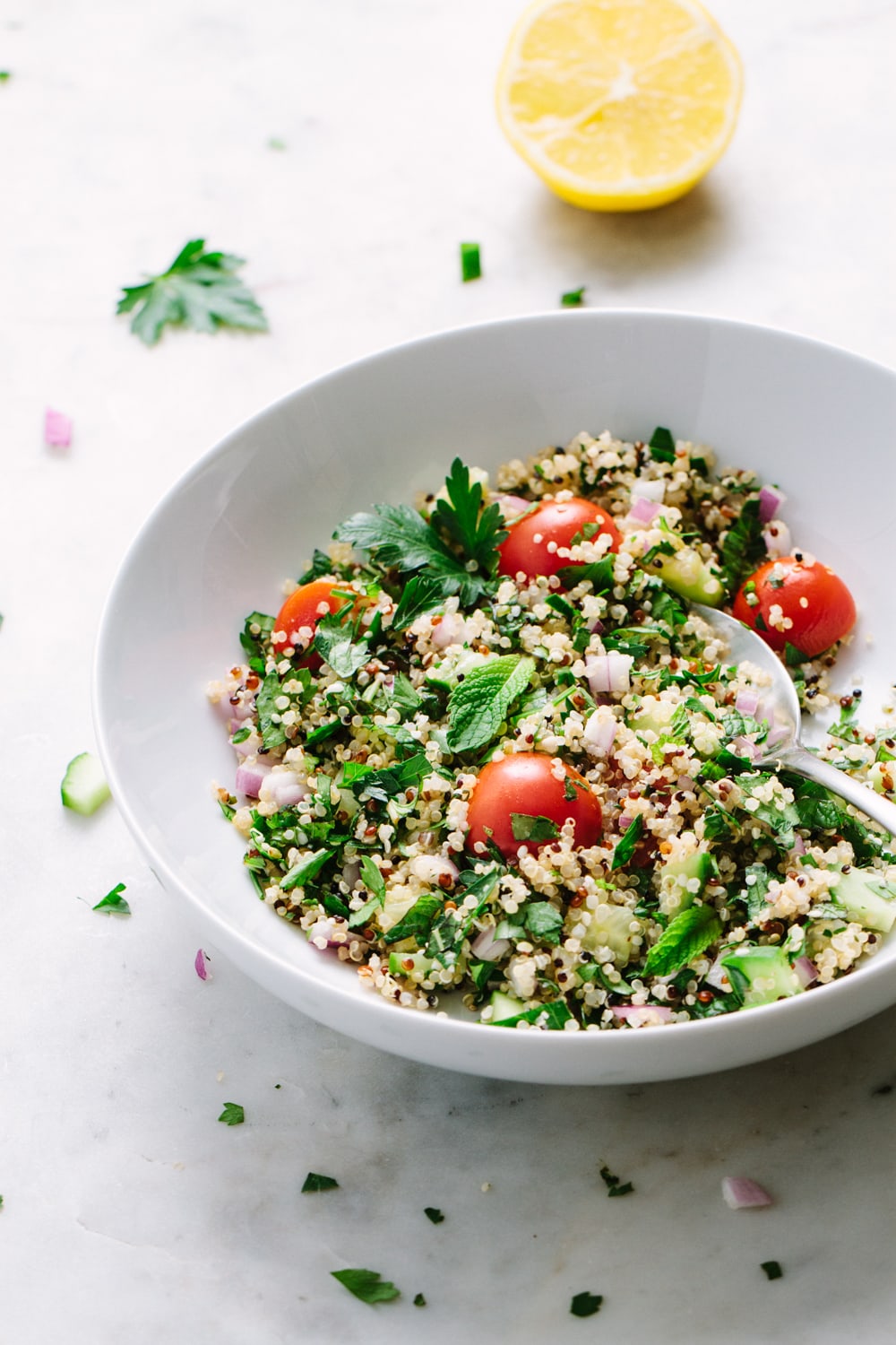 side angle view of a white bowl with serving of healthy quinoa tabbouleh with hemp hearts.
