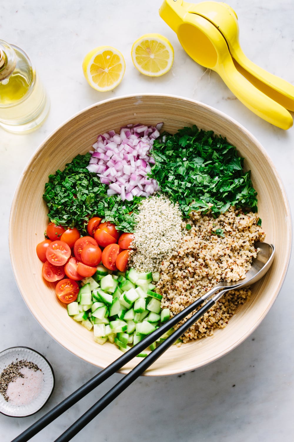 top down view of prepared ingredients for quinoa tabbouleh added to a large mixing bowl.