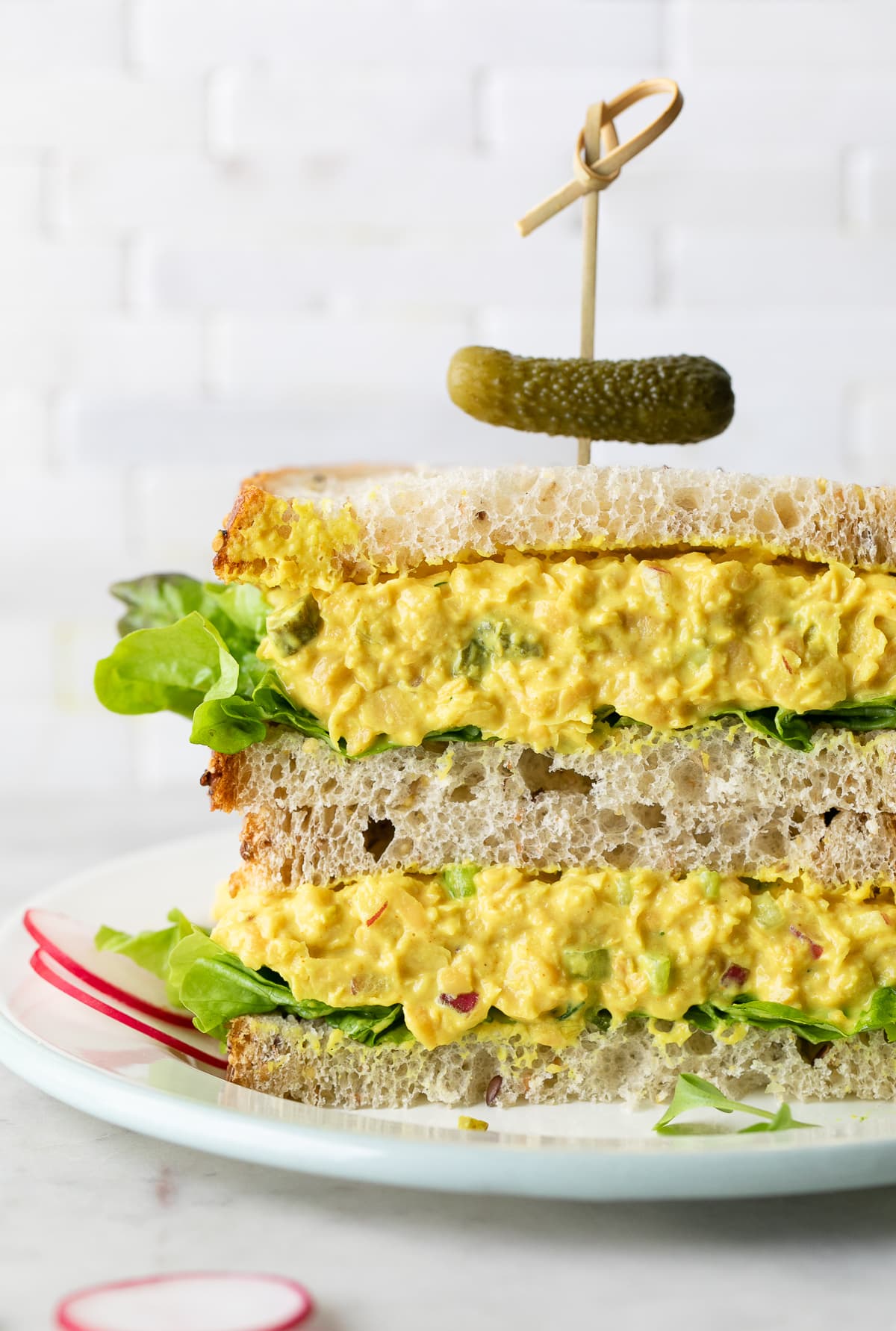 head on view of chickpea egg salad sandwich halves stacked.