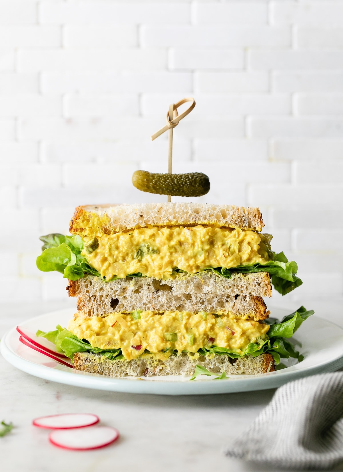 head on view of chickpea egg salad sandwich halves stacked.