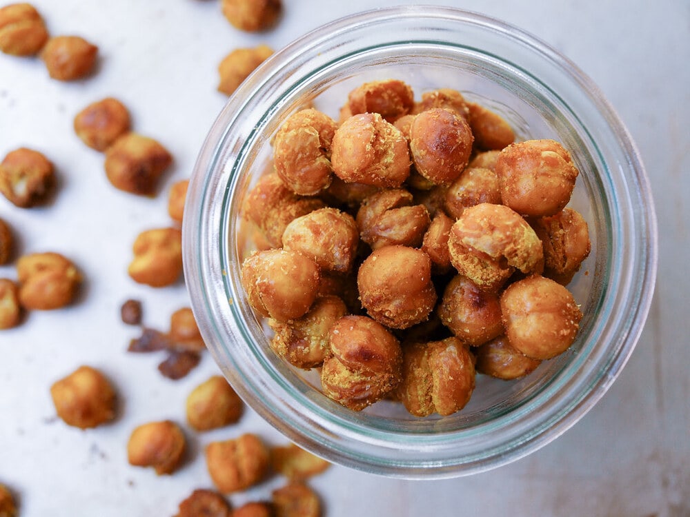 top down view of a glass jar filled with curry sriracha roasted chickpeas.