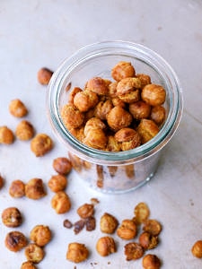 top down side angle view of a glass jar filled with curry sriracha roasted chickpeas.