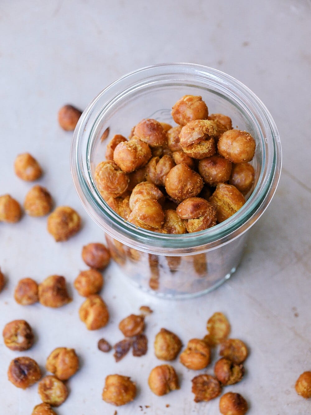 top down side angle view of a glass jar filled with curry sriracha roasted chickpeas.