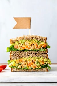 head on view of the best mashed chickpea salad sandwich cut in half and stacked.