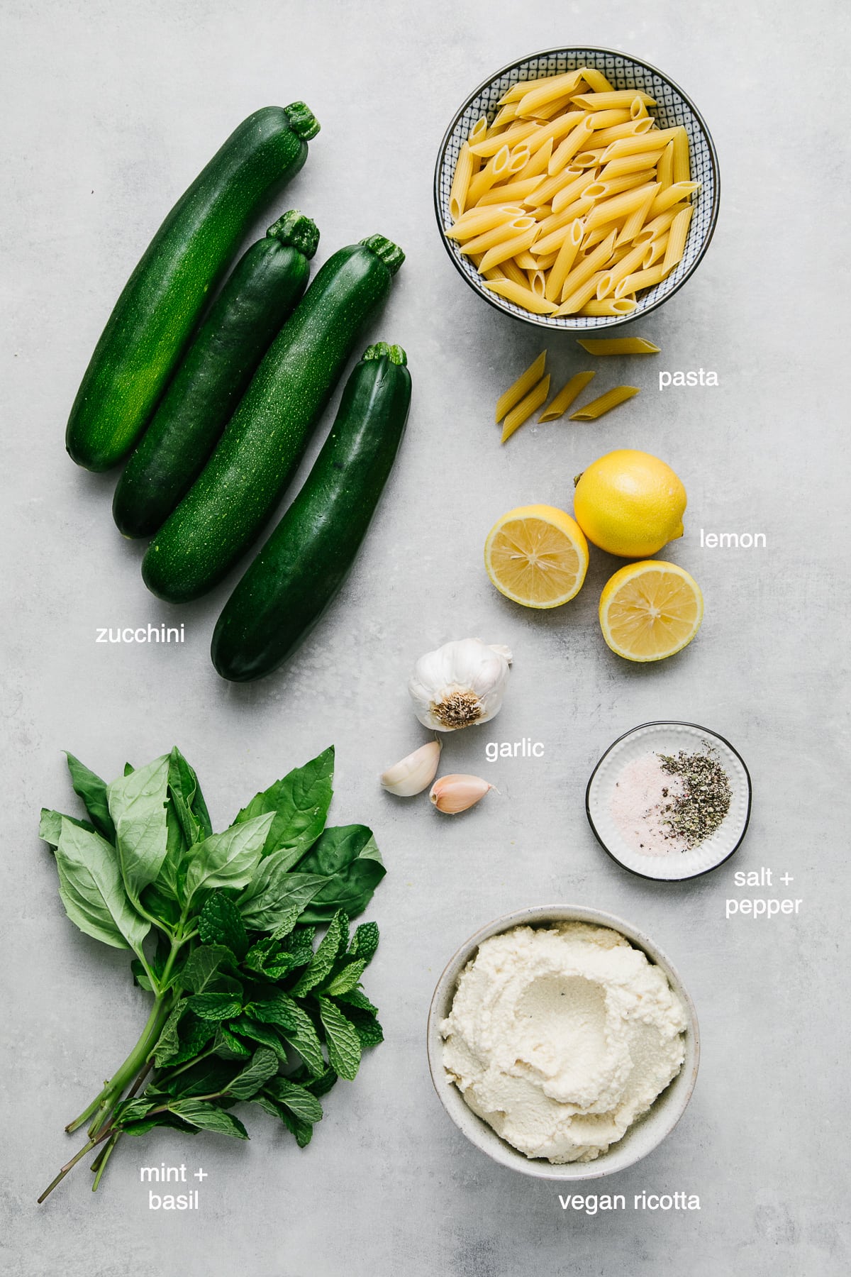 top down view of ingredients used to make vegan zucchini ricotta pasta with basil and mint.