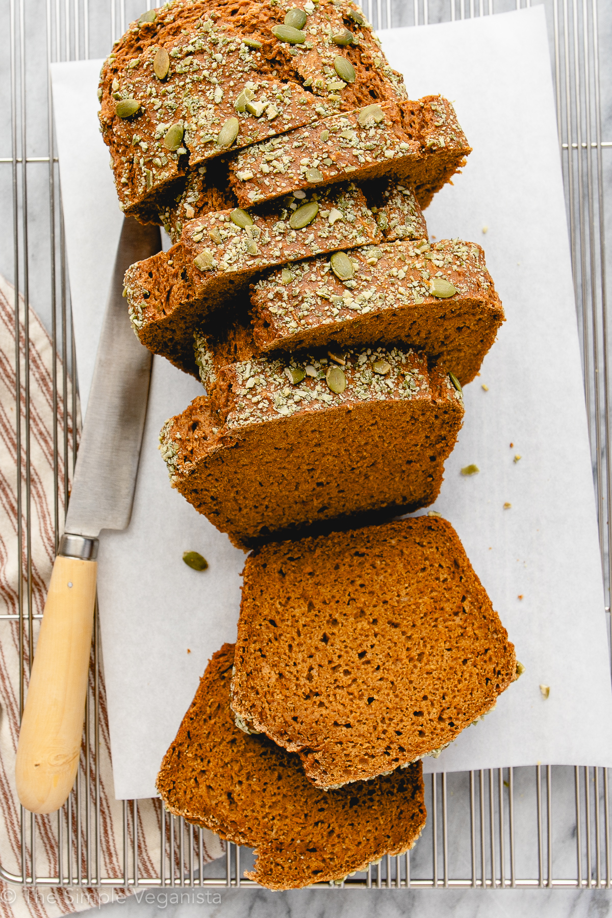 top down view of sliced pumpkin bread with items surrounding.