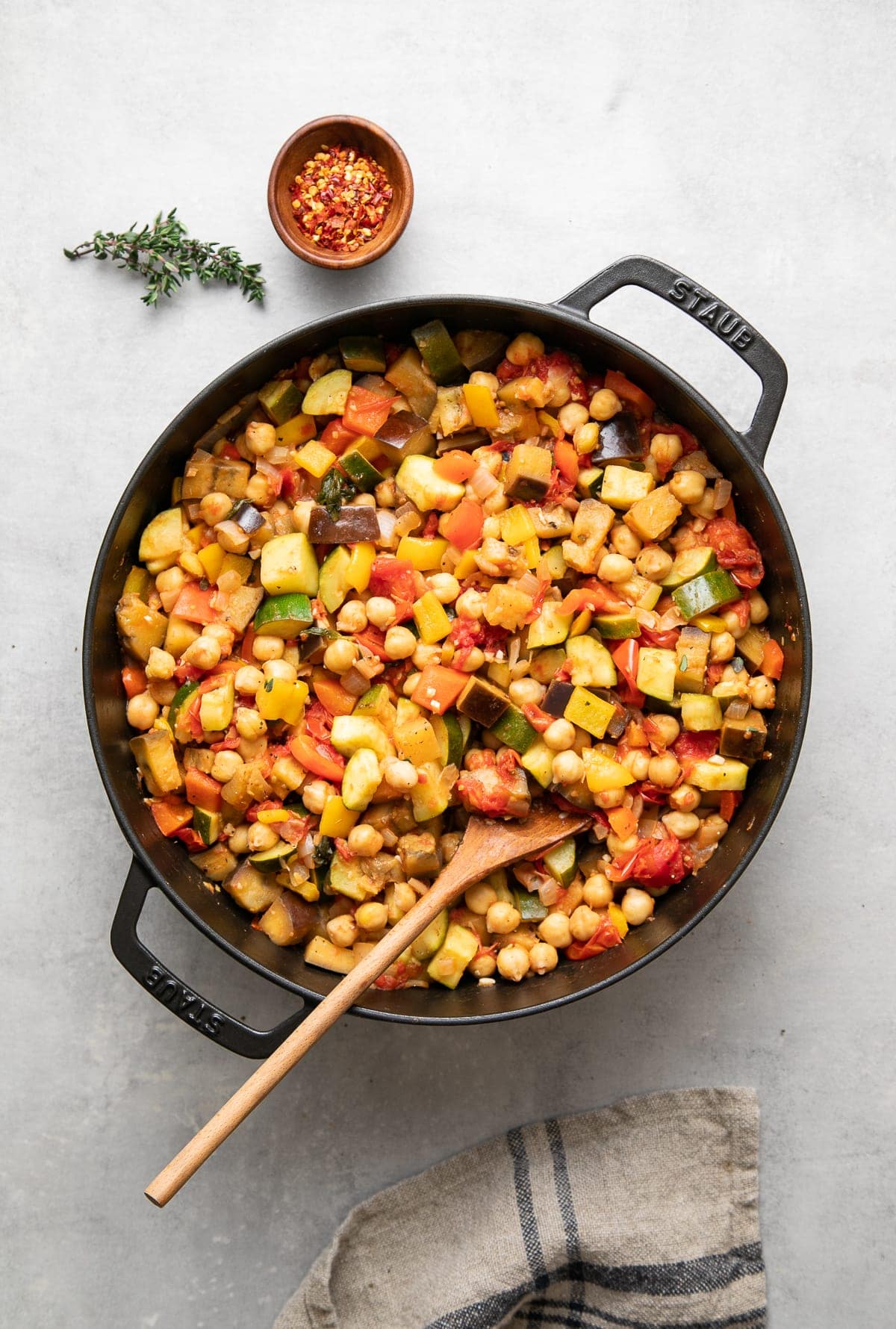 top down view of freshly made pot of chickpea ratatouille with items surrounding.