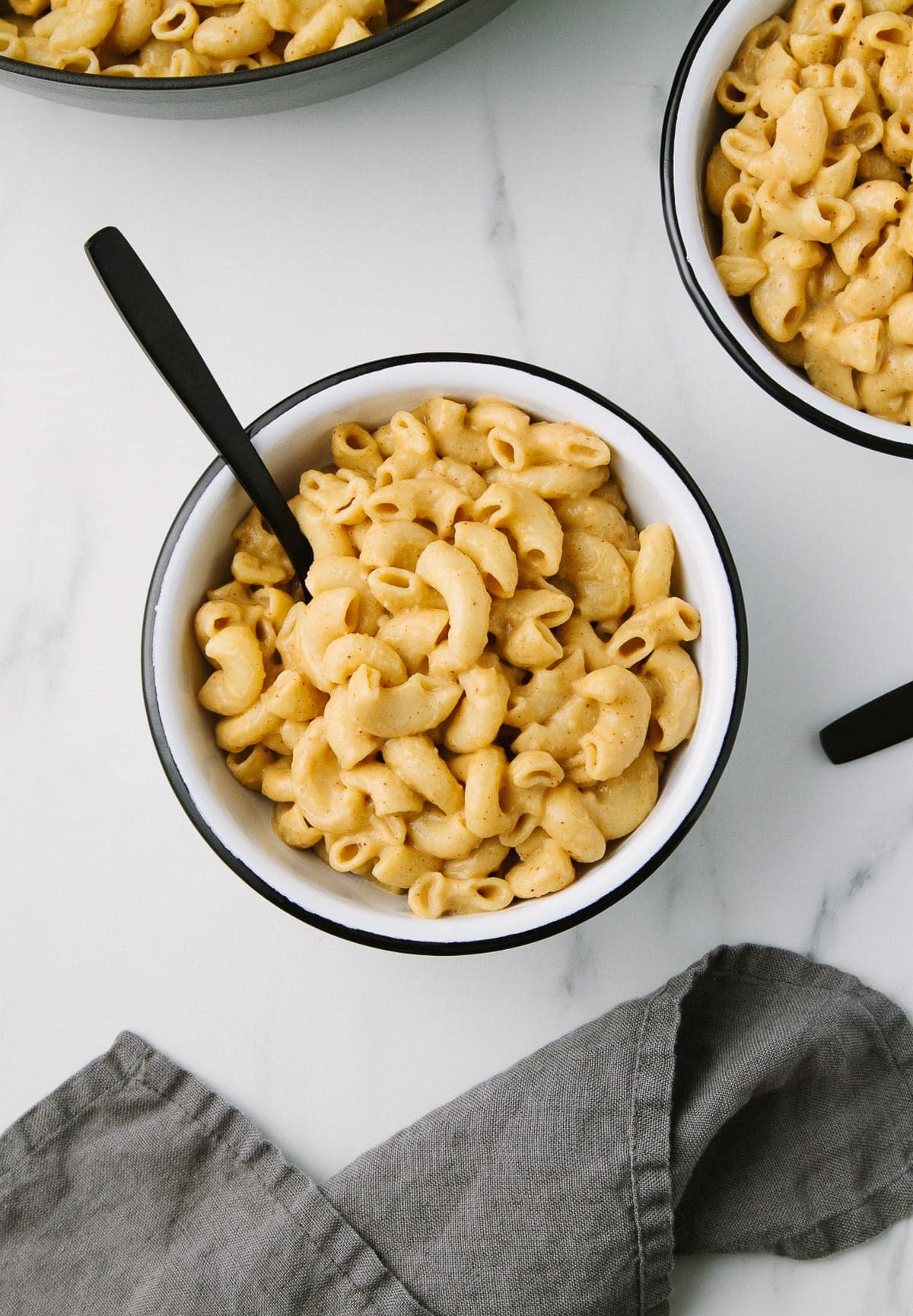top down view of a white bowl with black rim filled with easy spicy vegan mac and cheese.