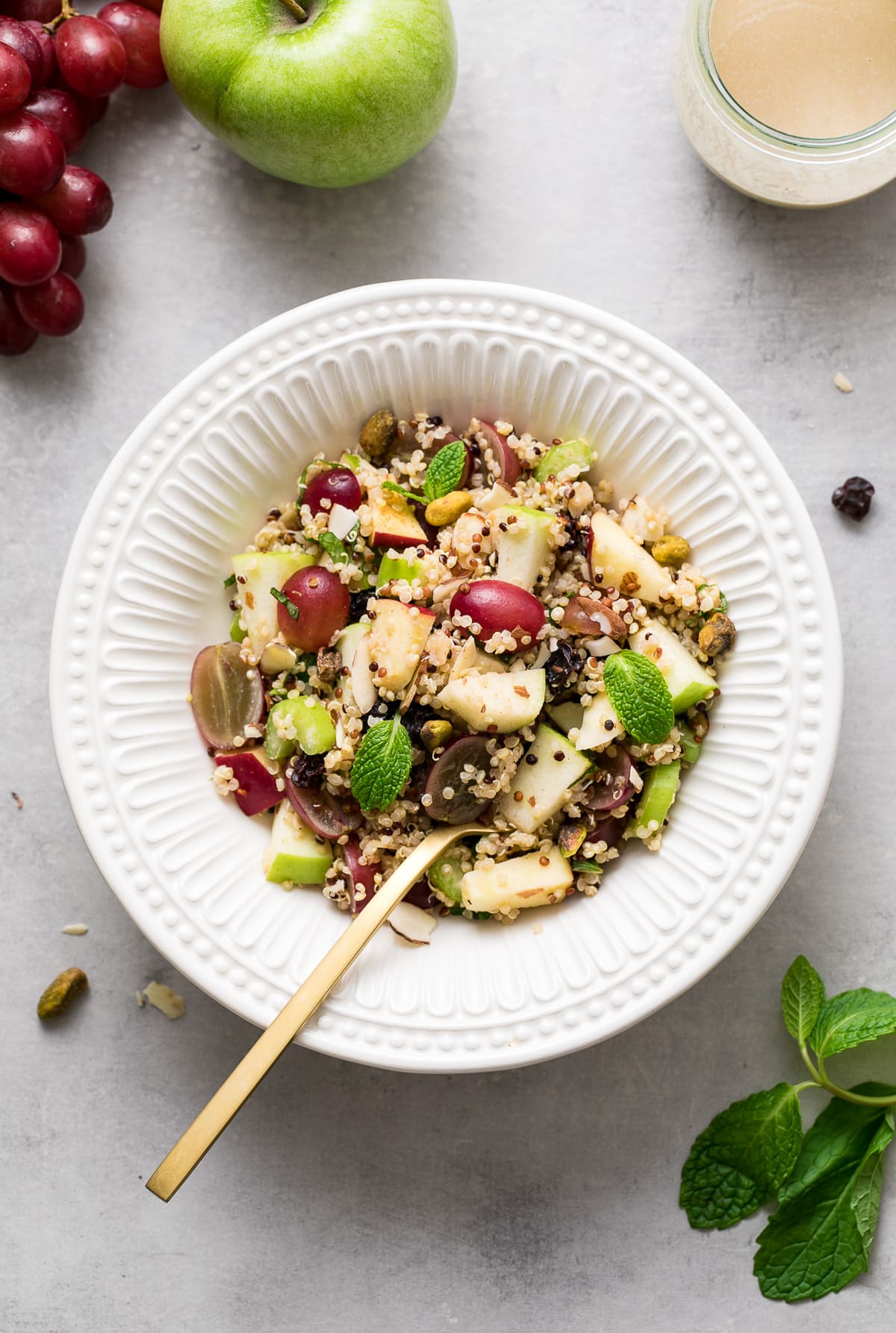 top down view of a white bowl with a serving of healthy vegan apple quinoa salad.