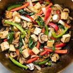 top down view of freshly made thai basil stir fry with tofu in a wok.