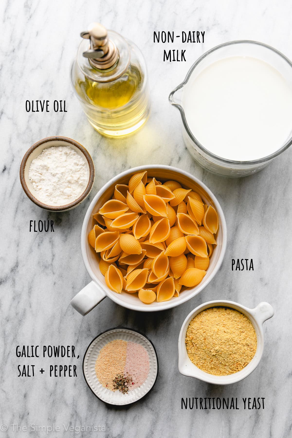 top down view of ingredients used to make vegan spicy mac and cheese recipe with nutritional yeast, flour and oil.