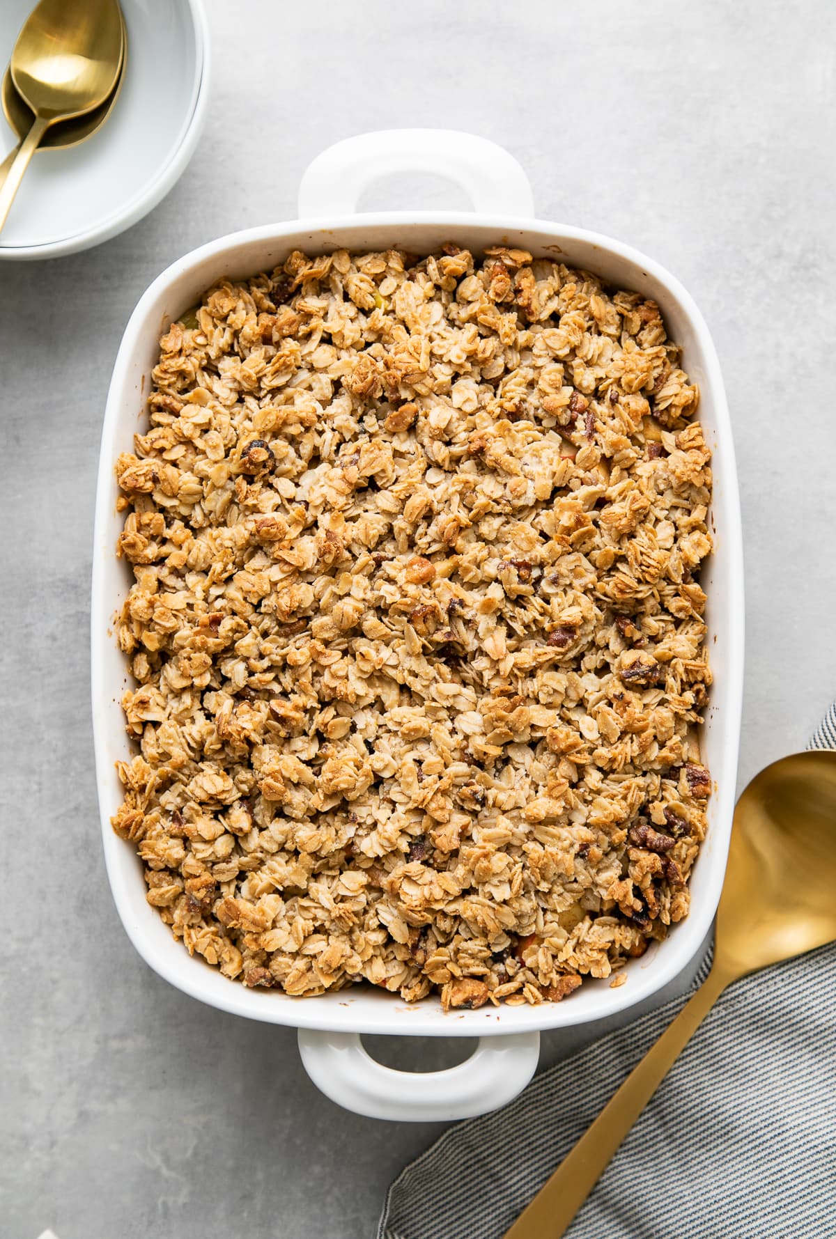 top down view of freshly made healthy apple crisp in a white baking dish.