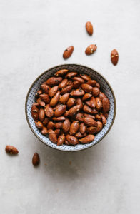 top down view of naturally sweetened roasted almonds in a blue and white bowl.
