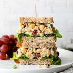 head on view of vegan chicken salad sandwich cut in half and stacked.