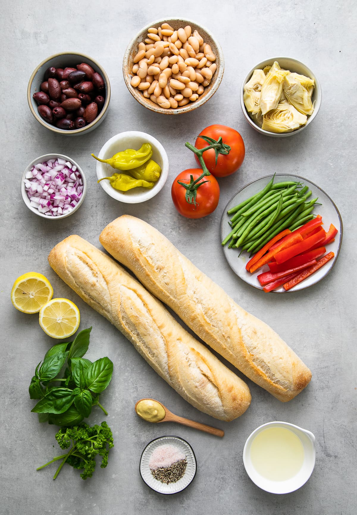 top down view of ingredients used to make veggie pan bagnat nicoise salad sandwich.