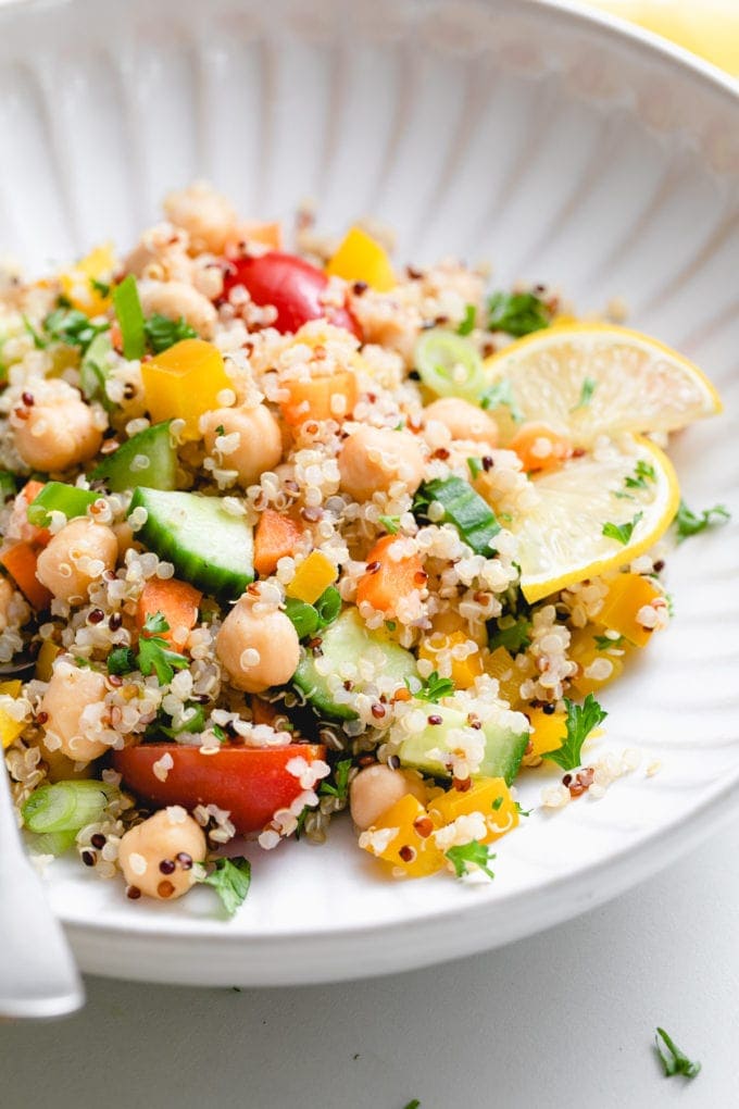 side angle view of lemon quinoa chickpea salad in a white bowl.