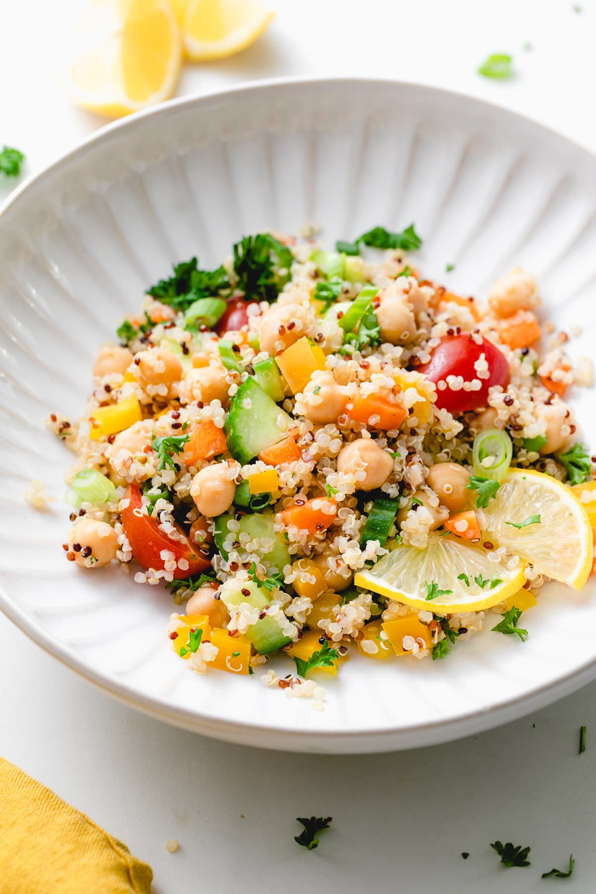 side angle view of lemon quinoa chickpea salad in a white bowl.