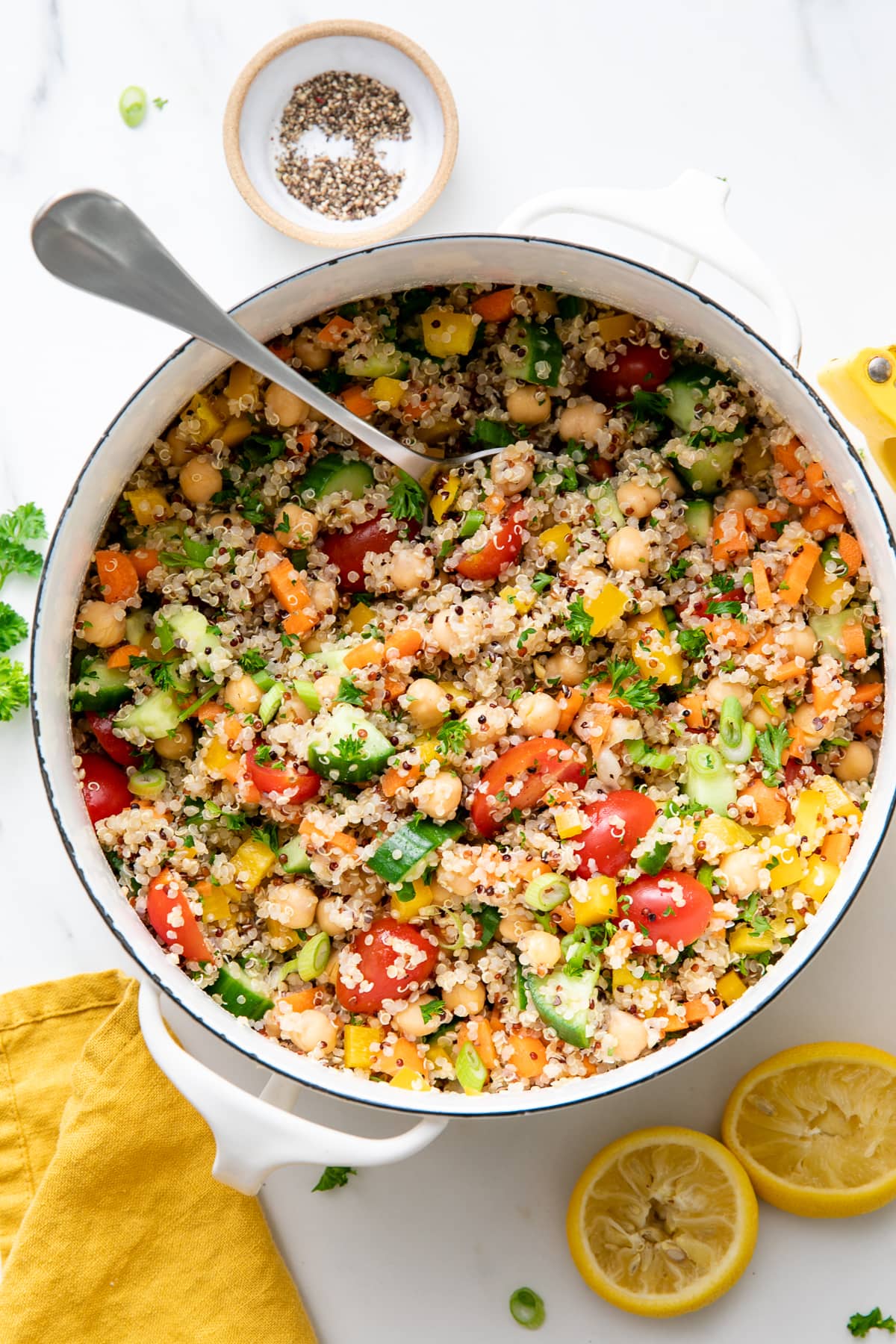 top down view of pot of freshly made healthy lemon quinoa chickpea salad with items surrounding.