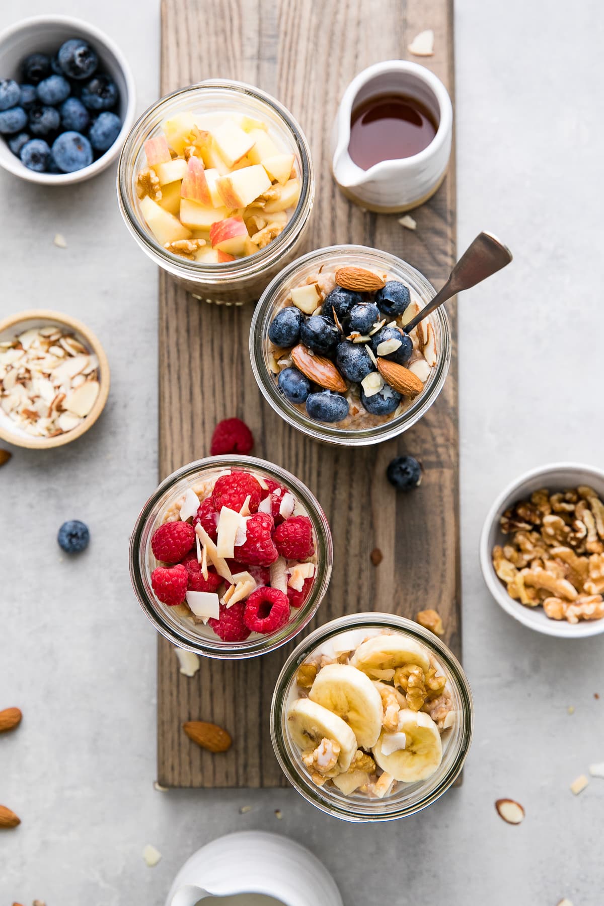 top down view of glass jars with steel cut oats and various fruits and nuts.