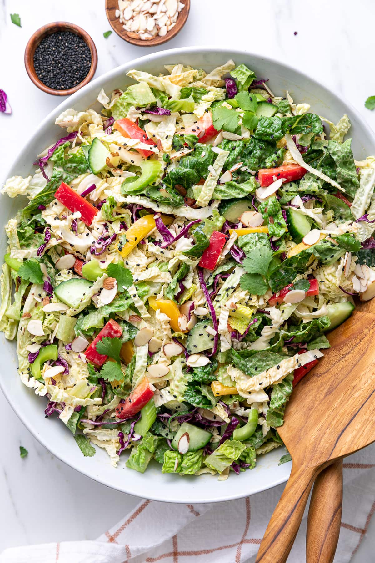 top down view of Asian chopped salad in a bowl with items surrounding.