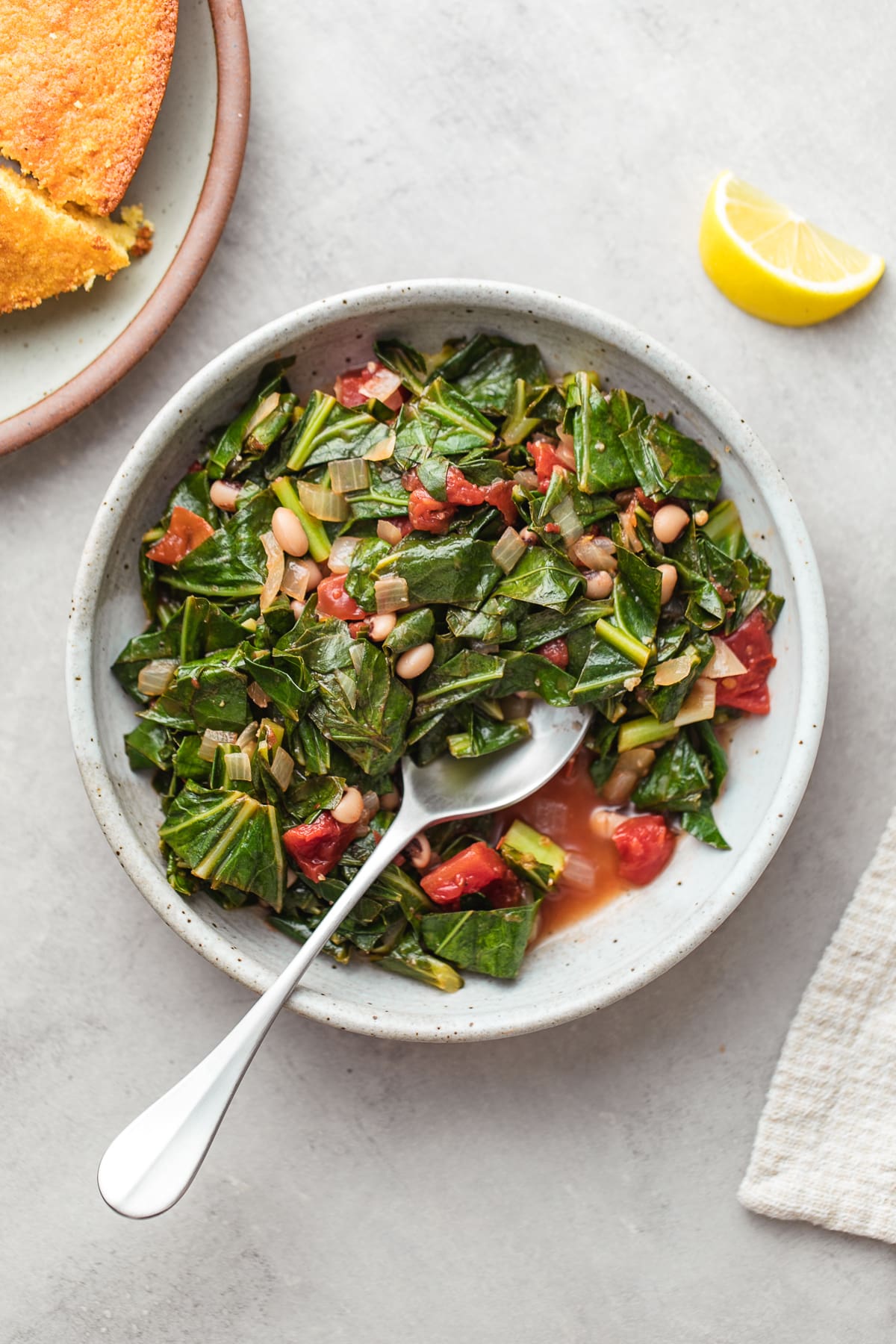 top down view of healthy vegan collard greens in a small bowl with spoon.