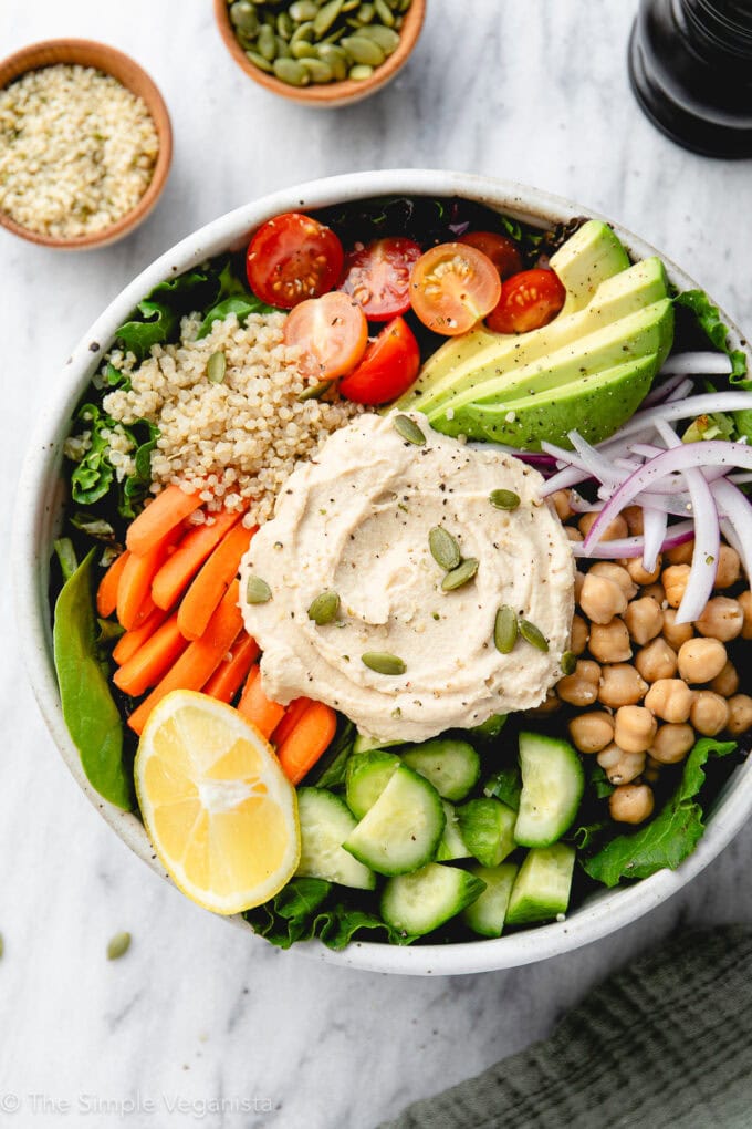 top down view of hummus bowl with items surrounding.